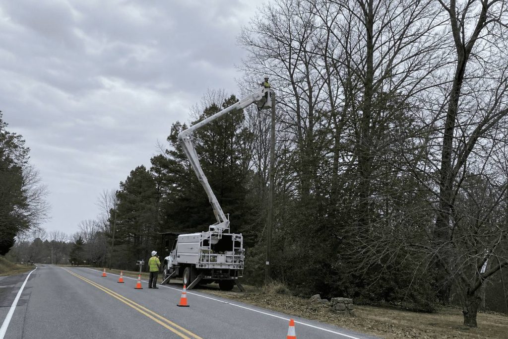Two crew feeding brush into a chipper loading into a dump truck in Danville, Virginia